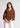 Woman wearing rust textured shirt with white trousers