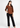 Rust V-neck top with black trousers, full-length look
