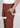 Rusty brown trousers close-up with pintuck and pocket labels