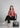 Woman seated in sunset peach shirt and black trousers
