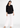 Black V-neck top with white trousers, full-length look