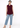 Burgundy plum sleeveless top with blue jeans, full-length look
