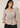 Front view of a model wearing the beige Waist Tie-up Shirt Top with a notched collar, three-quarter sleeves and gathered tie waist.