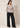 Full-length view of the beige Waist Tie-up Shirt Top styled with black wide-leg trousers and pointed heels.