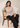 Seated model wearing the beige Waist Tie-up Shirt Top with black trousers, showing the front waist tie and notched collar.