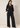 Full-length view of the black Waist Tie-up Shirt Top styled with black wide-leg trousers and pointed heels.