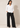 Full-length view of the white Waist Tie-up Shirt Top styled with black wide-leg trousers and pointed heels.