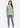 Golden olive V-neck top with blue jeans, full-length look