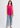 Hot pink sleeveless top with blue jeans, full-length look