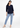 Navy V-neck top with blue jeans, full-length look