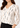 V-neck and abstract print close-up, off-white work top