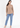 Soft beige V-neck top with blue jeans, full-length look