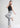 Model in urban grey trousers, one leg raised