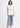 White sleeveless top with blue jeans, full-length look